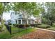 Charming two-story home with a well-manicured lawn, black metal fence, and inviting covered porch at 6015 Shell Ridge Dr, Lithia, FL 33547