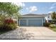 Spacious two-car garage with a wide driveway, complemented by tasteful landscaping and surrounding greenery at 6015 Shell Ridge Dr, Lithia, FL 33547