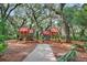 Charming community playground with playhouses surrounded by mature trees and a mulch ground at 6015 Shell Ridge Dr, Lithia, FL 33547