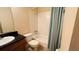 Bathroom features a single sink vanity with a black countertop, and a shower/tub with a blue curtain at 631 Haven Pl, Tarpon Springs, FL 34689