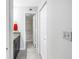 Hallway view of updated bathroom with granite countertops and tiled floors and shower/tub combo at 650 Island Way # 204, Clearwater Beach, FL 33767