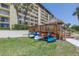 Exterior view of waterfront condo community with kayak storage under tiki hut for easy access to water at 650 Island Way # 204, Clearwater Beach, FL 33767
