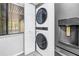 Highlighting a modern, stacked washer/dryer beside a new stainless-steel refrigerator at 650 Island Way # 204, Clearwater Beach, FL 33767
