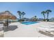Beautiful waterfront pool area with lounge chairs, tables, and tiki bar overlooking the water at 650 Island Way # 204, Clearwater Beach, FL 33767
