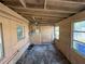 Unfinished room featuring wood-paneled walls, windows, and concrete flooring at 6706 Del Prado Ter, New Port Richey, FL 34652