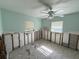 View of a room undergoing renovation with exposed wall studs, ceiling fan and tile flooring at 6706 Del Prado Ter, New Port Richey, FL 34652