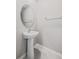 Cozy powder room with a pedestal sink, oval mirror, and neutral paint at 7205 Ronnie Gardens Ct, Tampa, FL 33619
