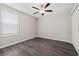 A well-lit bedroom features a modern ceiling fan and stylish dark wood-look flooring at 7205 Ronnie Gardens Ct, Tampa, FL 33619