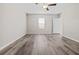 Spacious bedroom featuring wood-look flooring, a modern ceiling fan, and a window with blinds at 7205 Ronnie Gardens Ct, Tampa, FL 33619