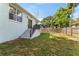 View of backyard with steps to access yard, a fence, and mature trees at 8605 N Taliaferro Ave, Tampa, FL 33604