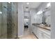 Bathroom featuring a double sink vanity, a glass enclosed shower with custom tile, and modern fixtures at 8605 N Taliaferro Ave, Tampa, FL 33604