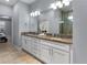 Bright bathroom boasting a double sink vanity with granite countertops and tiled floors at 8605 N Taliaferro Ave, Tampa, FL 33604