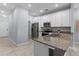Modern kitchen with granite counters and stainless steel appliances, leading to a hallway at 8605 N Taliaferro Ave, Tampa, FL 33604