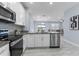 Modern kitchen featuring stainless steel appliances, granite countertops, and white cabinetry at 8605 N Taliaferro Ave, Tampa, FL 33604