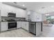 Modern kitchen featuring stainless steel appliances, granite countertops, and white cabinetry at 8605 N Taliaferro Ave, Tampa, FL 33604