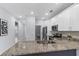 Bright kitchen with granite counters and stainless steel appliances, blending into adjacent room at 8605 N Taliaferro Ave, Tampa, FL 33604