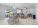 Open-concept living space featuring a dining table, modern furniture, and natural light at 8605 N Taliaferro Ave, Tampa, FL 33604