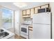Cozy kitchen with white appliances and cabinets, including a window with a view at 9100 Dr Martin Luther King Jr N St # 314, St Petersburg, FL 33702