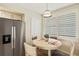 Bright breakfast nook features a round table, plantation shutters, and stainless steel appliances at 960 Starkey Rd # 7202, Largo, FL 33771