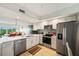 Well-equipped kitchen with stainless steel appliances, white cabinetry, and mosaic tile backsplash at 960 Starkey Rd # 7202, Largo, FL 33771