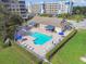 Aerial view of community pool, lounge chairs, tables with umbrellas, and a nearby cabana at 960 Starkey Rd # 7202, Largo, FL 33771