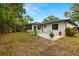 Landscaped backyard featuring a tiled patio area and lush green lawn at 1047 Deer Hollow Way, Sarasota, FL 34232