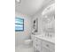 Bathroom featuring a white vanity, toilet, and a decorative mirror at 1047 Deer Hollow Way, Sarasota, FL 34232