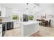Modern kitchen featuring an island with white countertop and stainless steel appliances with an adjacent dining area at 1047 Deer Hollow Way, Sarasota, FL 34232