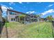 View of backyard and screened in patio with pool, lush green grass and palm trees at 11227 Hawks Fern Dr, Riverview, FL 33569