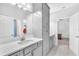Bright bathroom featuring gray cabinets, double sinks, and a spacious layout leading to a bedroom at 11227 Hawks Fern Dr, Riverview, FL 33569