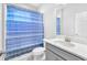 Cozy bathroom with a blue striped shower curtain, gray cabinets, and a white stone countertop at 11227 Hawks Fern Dr, Riverview, FL 33569