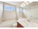 Well-lit bathroom features a shower-tub combo and a large vanity with a stylish countertop and a framed mirror at 12124 Colonial Estates Ln, Riverview, FL 33579