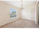 Bright dining room with a chandelier, large window, and neutral carpeting at 12124 Colonial Estates Ln, Riverview, FL 33579