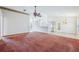 Open-concept living space featuring carpet flooring, ceiling fan, and seamless flow to the kitchen at 12124 Colonial Estates Ln, Riverview, FL 33579