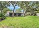 Large backyard with mature trees and screened-in porch at 14 Idlewilde Dr, Safety Harbor, FL 34695