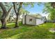 Backyard view with lawn and mature trees near the house at 14 Idlewilde Dr, Safety Harbor, FL 34695