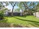 Spacious backyard featuring green grass and mature shade trees at 14 Idlewilde Dr, Safety Harbor, FL 34695