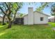 View of the backyard featuring a screened-in patio and lush green grass at 14 Idlewilde Dr, Safety Harbor, FL 34695