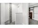 Shower featuring gray stone detail and a built-in bench, adjoining a custom-built shelving system in the closet at 14 Idlewilde Dr, Safety Harbor, FL 34695