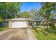 Charming single-story home featuring a well-maintained lawn, stone accents, and a two-car garage, situated under a bright blue sky at 14 Idlewilde Dr, Safety Harbor, FL 34695