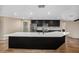 Modern kitchen features dark cabinetry, stainless steel appliances, and a large island with a white countertop at 14 Idlewilde Dr, Safety Harbor, FL 34695