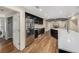 Open kitchen with stainless steel appliances, dark cabinets, stone fireplace and luxury vinyl plank flooring at 14 Idlewilde Dr, Safety Harbor, FL 34695