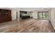 Large, open-concept area with hardwood flooring, kitchen island, and glass doors leading to the outside, designed for modern living at 14 Idlewilde Dr, Safety Harbor, FL 34695