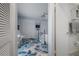 View of a light-blue bedroom from doorway, featuring floral rug, bed, ceiling fan and mirrored closet doors at 15344 E Pond Woods Dr, Tampa, FL 33618