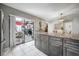 Modern kitchen with island, granite countertops, stainless appliances, and access to patio at 15344 E Pond Woods Dr, Tampa, FL 33618