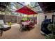 Outdoor patio with dining set under red umbrella and string lights in enclosed lanai at 15344 E Pond Woods Dr, Tampa, FL 33618