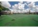 Community tennis court surrounded by trees and residential buildings, with a green playing surface at 15344 E Pond Woods Dr, Tampa, FL 33618