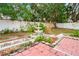 Landscaped backyard with a decorative fountain, brick patio and garden area creating a serene outdoor space at 18005 Palm Breeze Dr, Tampa, FL 33647