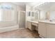 Bright bathroom featuring dual sinks, large mirror, soaking tub, and separate shower at 18005 Palm Breeze Dr, Tampa, FL 33647