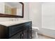Stylish bathroom features a black vanity with quartz countertop, and decorative mirror at 18005 Palm Breeze Dr, Tampa, FL 33647